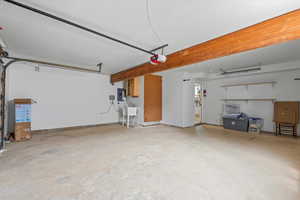 Garage featuring electric panel and a garage door opener