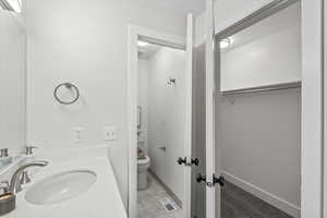 Bathroom with vanity, light tile patterned floors, and a spacious closet