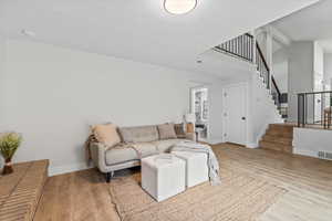 Living room with light wood-style floors and stairs