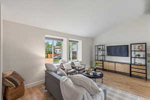 Living area featuring light wood finished floors and vaulted ceiling