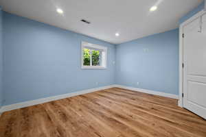 Empty room with recessed lighting and wood finished floors