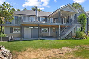 Back of house with a patio area, a shingled roof, stairway, and a lawn