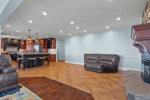 Living room with recessed lighting, light tile patterned floors, and ornamental molding