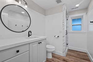 Bathroom featuring light wood-type flooring, vanity, and a stall shower