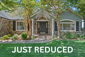 Doorway to property with stone siding and a lawn