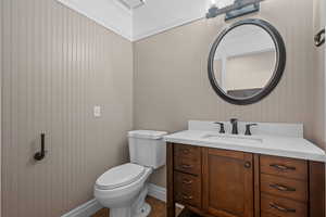 Half bath with vanity and dark tile patterned flooring