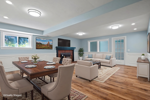 Dining room featuring recessed lighting, a decorative wall, wainscoting, a brick fireplace, and light wood-style flooring