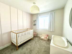Bedroom with a crib and carpet floors