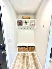 Mudroom with light wood-style flooring and baseboards