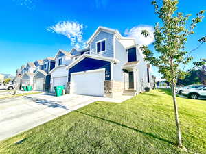 Traditional home featuring concrete driveway, a front lawn, a residential view, and an attached garage