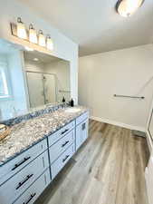 Full bath with vanity, a shower stall, light wood finished floors, and a garden tub