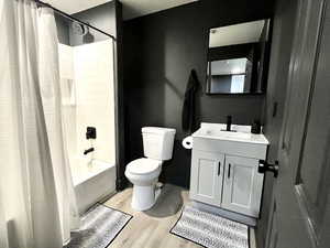 Bathroom featuring shower / bath combo, vanity, and light wood finished floors