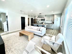 Living room with light wood-style flooring and recessed lighting