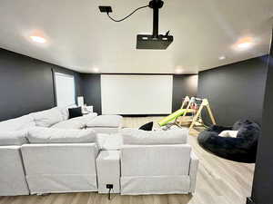 Cinema featuring light wood-style floors and recessed lighting