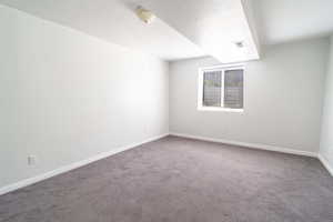 Empty room featuring a textured ceiling and carpet flooring