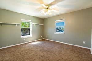 Carpeted empty room featuring a ceiling fan and a textured ceiling