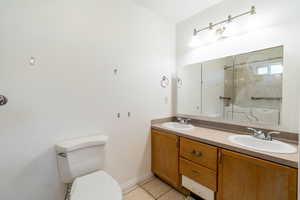 Bathroom featuring light tile patterned floors, double vanity, and tub / shower combination