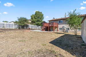 Fenced backyard with a wooden deck and stairway