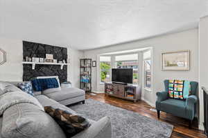 Living area with dark wood-style flooring and a textured ceiling
