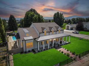 Modern farmhouse style home with a porch, roof with shingles, a standing seam roof, a metal roof, and a gate