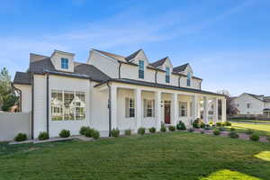 View of front of house with covered porch, brick siding, and a shingled roof