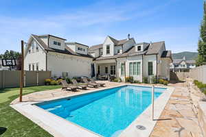 Back of house featuring a patio area, a fenced backyard, and a shingled roof