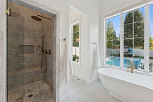 Bathroom with a stall shower and a freestanding tub