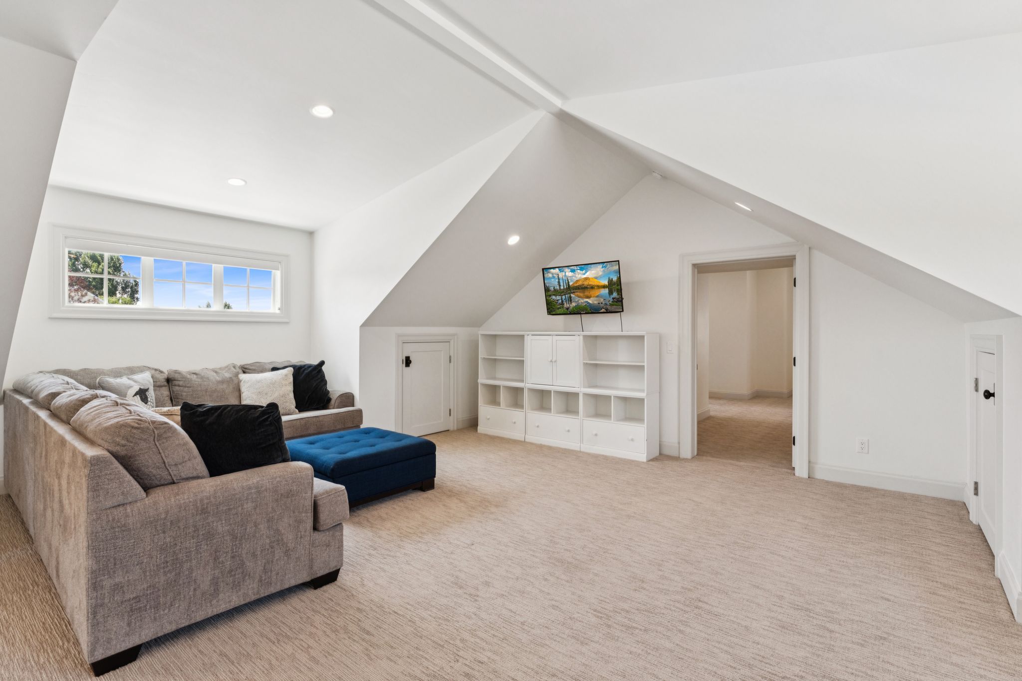 Living room with vaulted ceiling, light colored carpet, and recessed lighting