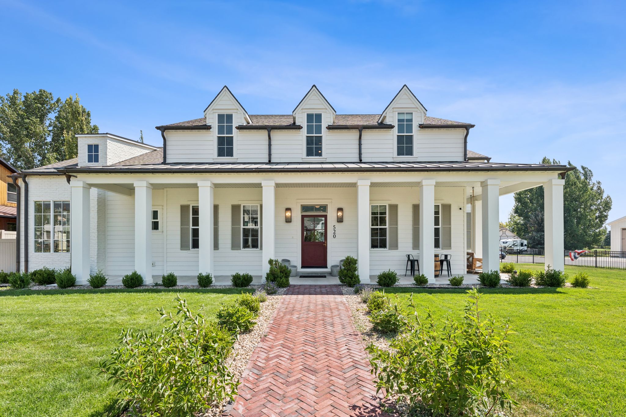 View of front of property featuring a porch, a standing seam roof, a shingled roof, and a metal roof