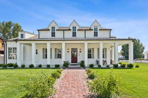 View of front of property featuring a porch, a standing seam roof, a shingled roof, and a metal roof