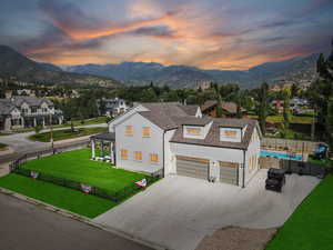 Modern farmhouse with concrete driveway, a mountain view, roof with shingles, and a garage
