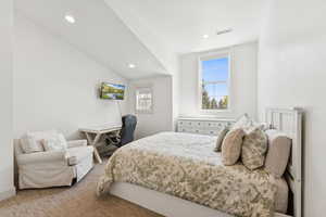 Carpeted bedroom with recessed lighting and lofted ceiling