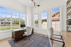 Home office with light wood-type flooring and recessed lighting