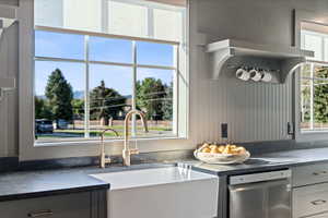 Kitchen featuring dishwasher and dark stone counters