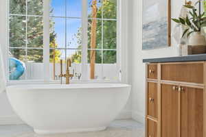 Bathroom featuring baseboards and a soaking tub