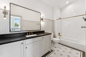Ensuite bathroom featuring shower / washtub combination, vanity, and light tile patterned floors
