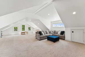 Living area featuring vaulted ceiling, carpet, and recessed lighting