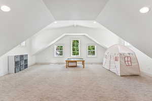 Additional living space featuring carpet flooring, vaulted ceiling, and recessed lighting