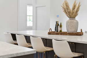 Kitchen with light stone countertops and a kitchen bar
