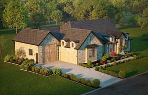 French country home featuring a front lawn, concrete driveway, and a garage