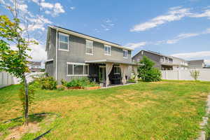 Large vinyl fenced backyard with mature fruit trees, garden, covered patio with lighting.