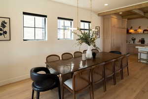 Dining room with light wood-type flooring, beam ceiling, and recessed lighting