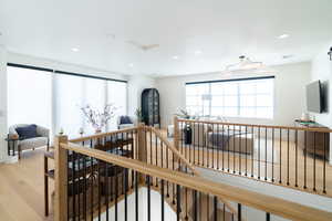 Stairs featuring wood finished floors and recessed lighting