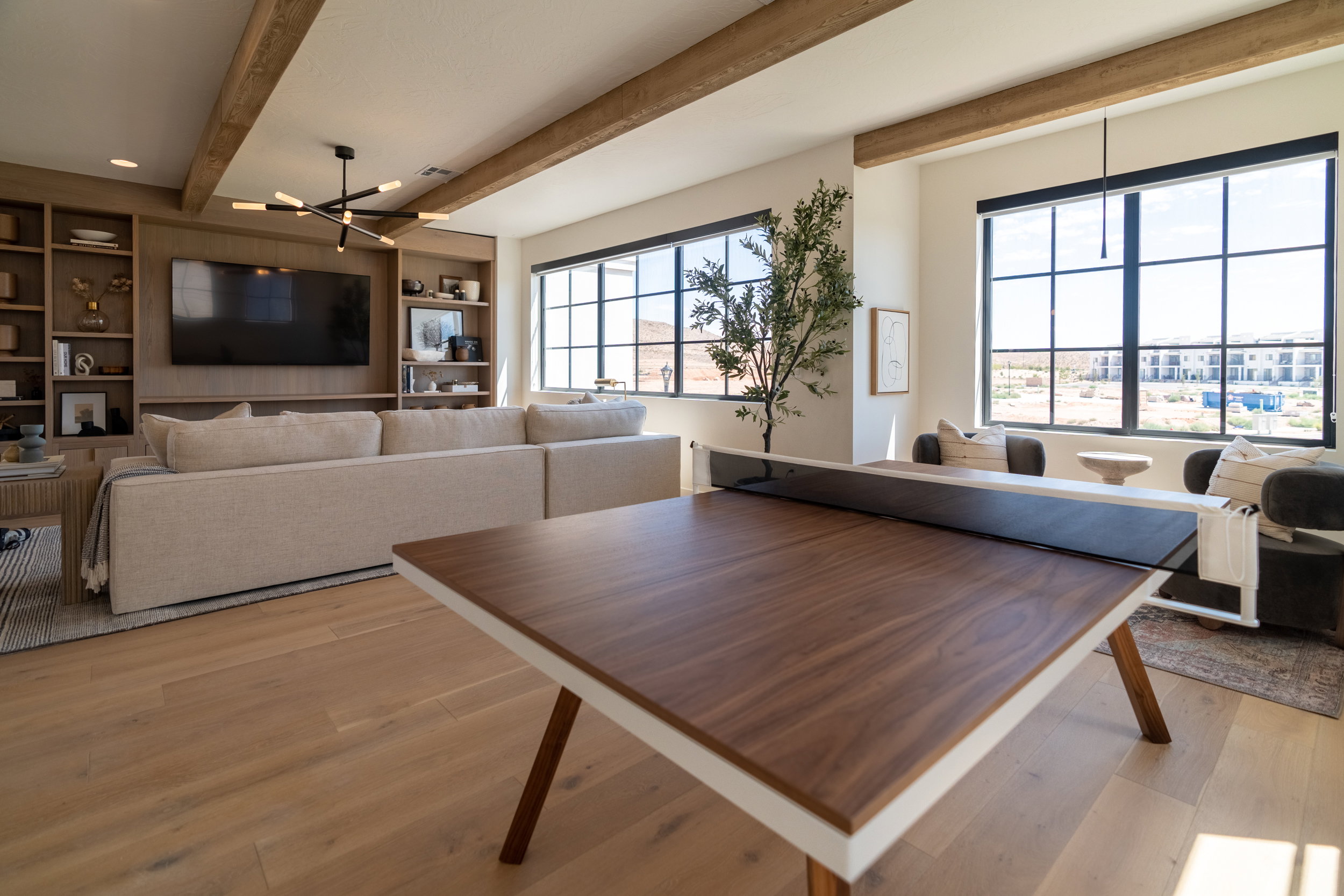 Dining room featuring beamed ceiling, light wood-style flooring, healthy amount of natural light, and built in shelves