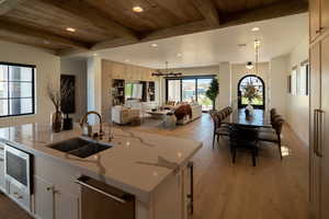 Kitchen with dark wood-style floors, recessed lighting, open floor plan, a center island with sink, and white cabinets