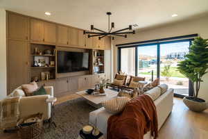 Living area with a textured ceiling, light wood finished floors, recessed lighting, and a chandelier