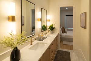 Bathroom featuring ensuite bathroom, double vanity, and light tile patterned floors
