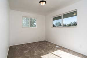 Empty room with carpet floors and baseboards