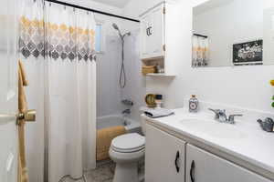 Bathroom featuring vanity, shower / tub combo, and light tile patterned flooring
