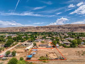 Aerial perspective of suburban area with property boundaries highlighted and a mountain backdrop